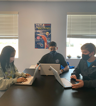three students working on computers